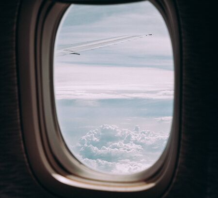 Clouds and sky through window of an aircraftの写真素材
