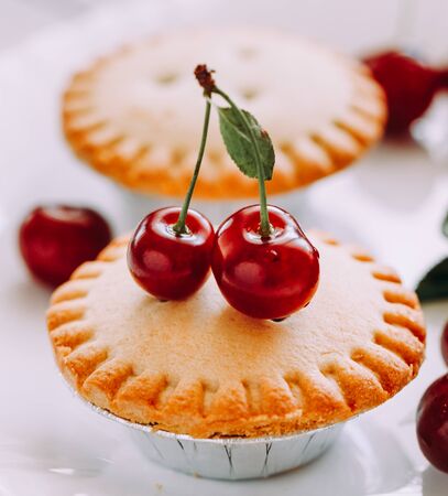 Cupcake with cherries on white wooden boardsの写真素材