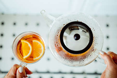 Modern glass teapot and cop of tea with lemon. Tea ceremony concept.の写真素材