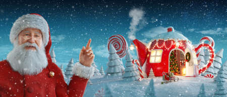 Santa Claus pointing at blank space. Amazing fairy house decorated at christmas in shape of teapot in magical forest with spurces and candy canes. Unusual christmas 3d illustrationの写真素材