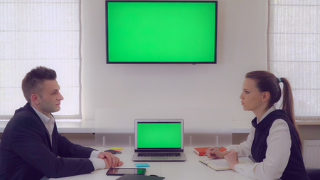 Businesswoman has meeting with client in boardroom. Manager explaining some details. Adult man wearing elegant suit listening what pointing female.の写真素材