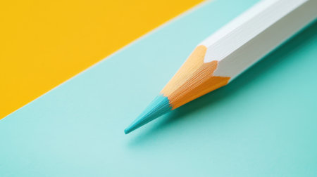 A close view of a pencil with a smooth gradient tip rests on a softly colored background. The complementary hues create a striking contrast, showing minimalist artistry.の素材