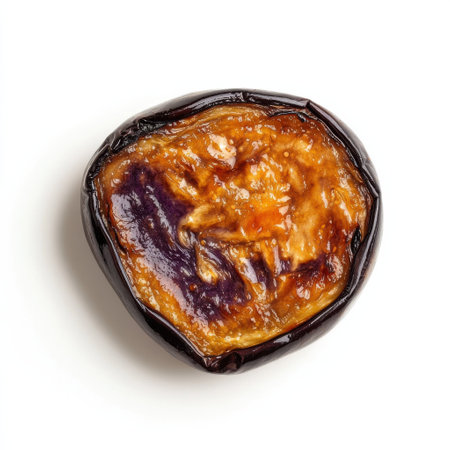 A single roasted eggplant slice displays a glossy, caramelized surface with deep purple and brown hues. The tender flesh suggests a rich, savory flavor profile ideal for various dishes.の素材