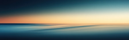 A serene gradient background showcases a transition from deep blue hues to warm orange tones, representing a beautiful sunset over a tranquil sea, creating a peaceful atmosphere.の素材
