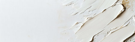 A soft white canvas features a subtle application of muted gold, showing an artistic blend of textures. The warm tones create a calming and elegant visual effect that invites closer inspection.の素材