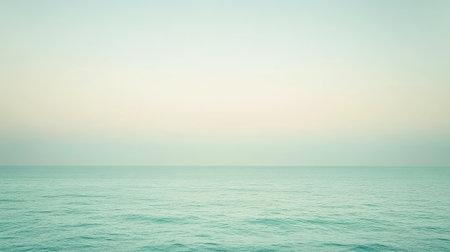 A soothing mint gradient transitions into white, creating a peaceful atmosphere above tranquil ocean waters. The soft blend evokes a sense of calm as day breaks.の素材