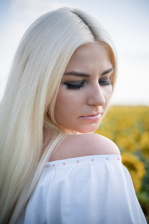 Portrait of the gorgeous young woman in the sunflower fieldの写真素材