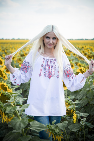 Portrait of the gorgeous young woman in the sunflower fieldの写真素材