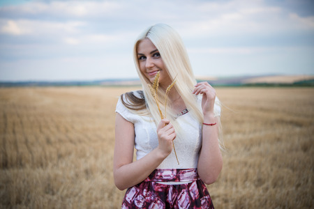 beautiful slim sexi blond lady with long hair in white long dressの写真素材