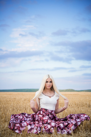 beautiful slim sexi blond lady with long hair in white long dressの写真素材