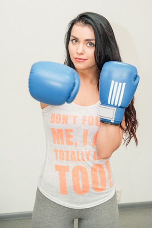 Girl in boxing gloves in the hallの写真素材