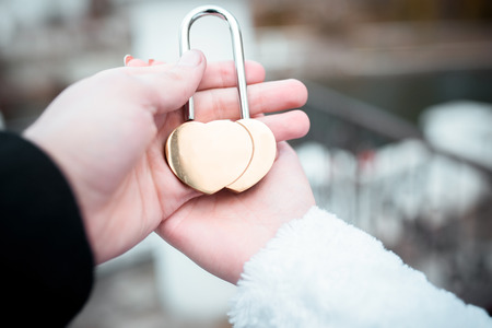 the bride and groom hold the lock in the form of heartの写真素材