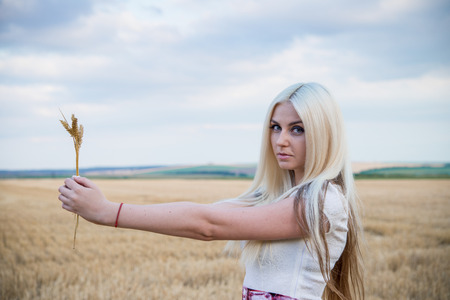beautiful slim sexi blond lady with long hair in white long dressの写真素材