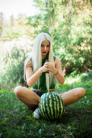 pretty girl outdoors eating fresh watermelonの写真素材