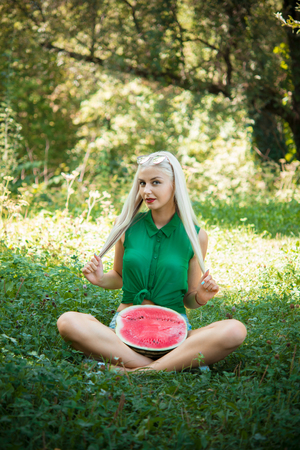 pretty girl outdoors eating fresh watermelonの写真素材