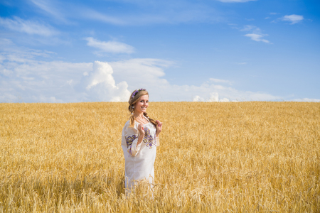 girl in national ukrainian clothes on the wheat fieldの写真素材