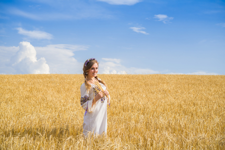 girl in national ukrainian clothes on the wheat fieldの写真素材