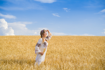 girl in national ukrainian clothes on the wheat fieldの写真素材