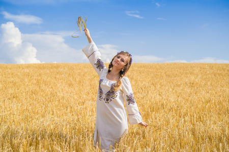 girl in national ukrainian clothes on the wheat fieldの写真素材