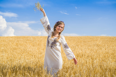 girl in national ukrainian clothes on the wheat fieldの写真素材