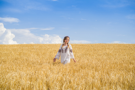 girl in national ukrainian clothes on the wheat fieldの写真素材