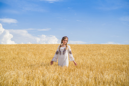 girl in national ukrainian clothes on the wheat fieldの写真素材