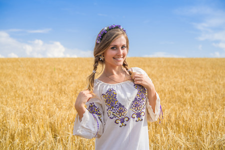 girl in national ukrainian clothes on the wheat fieldの写真素材
