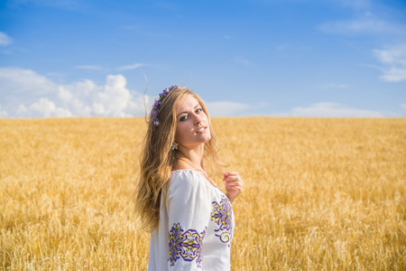 girl in national ukrainian clothes on the wheat fieldの写真素材