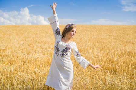 girl in national ukrainian clothes on the wheat fieldの写真素材