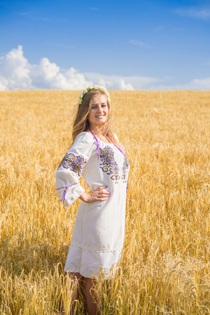 girl in national ukrainian clothes on the wheat fieldの写真素材