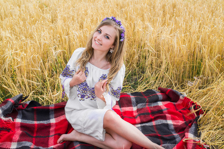 girl in national ukrainian clothes on the wheat fieldの写真素材