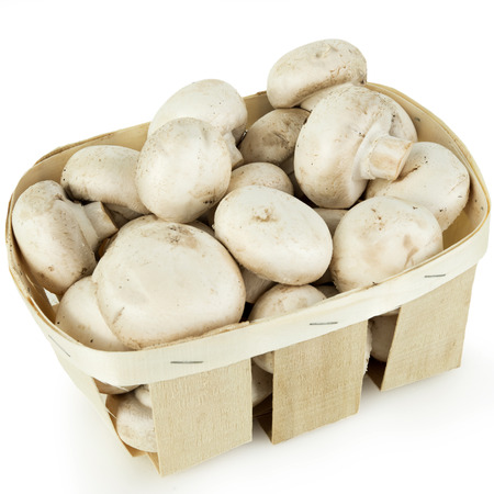 heap of fresh mushroom champignons in a basket isolated on white backgroundの写真素材