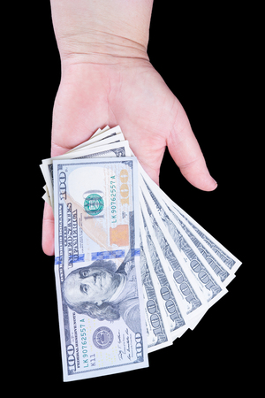 Woman's hand holding money isolated on black backgroundの写真素材
