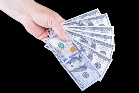 Woman's hand holding money isolated on black backgroundの写真素材