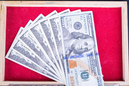Dollars background wooden casket with red fringeの写真素材
