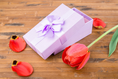 red wet tulipswith gift on wood backgroundの写真素材