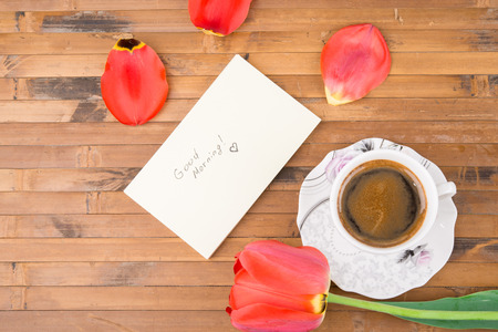 Cup of coffee, tulips and Good morning massage on wooden backgroundの写真素材