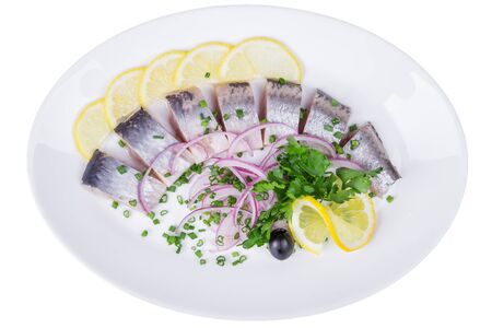 Isolated slices of salted herring fillet with lemon, onion, black olivesの写真素材