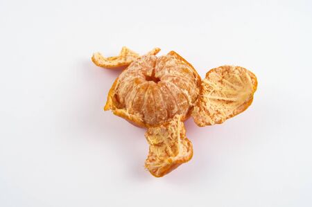 One peeled mandarin on a light backgroundの写真素材