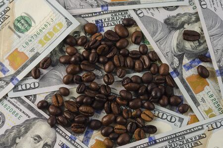 A bunch of coffee beans on the background of American dollarsの写真素材