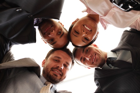 Mixed businessteam with heads together over whiteの写真素材