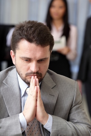 Portrait of a worried businessman with his team working behindの写真素材