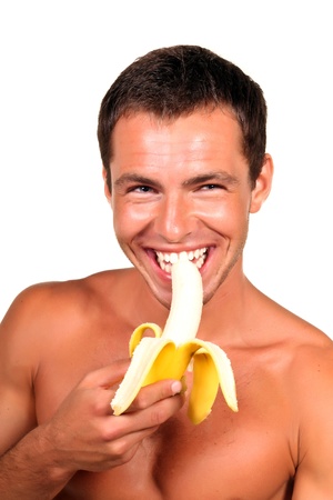 Young sexy handsome man eating bananaの写真素材