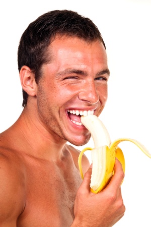 Young sexy handsome man eating bananaの写真素材