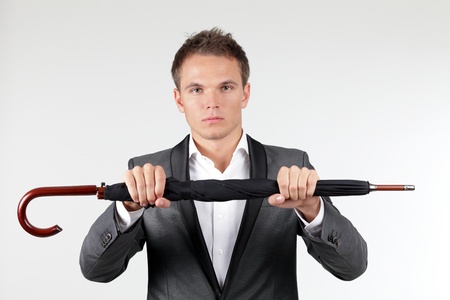 Confident businessman holding a folded umbrellaの写真素材