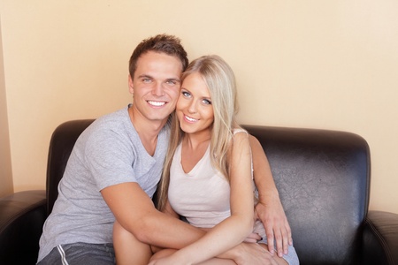 Young couple hugging on couchの写真素材