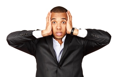 African businessman screaming with fear and a strange face expression (isolated on white)の写真素材