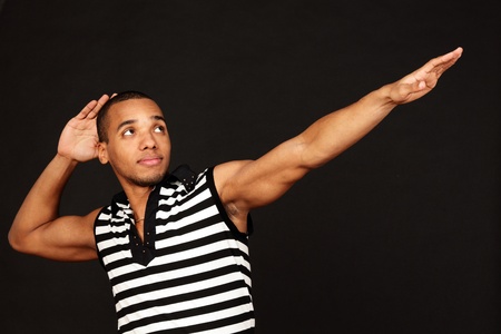 Young african-american strong man in striped t-shirt on dark backgroundの写真素材