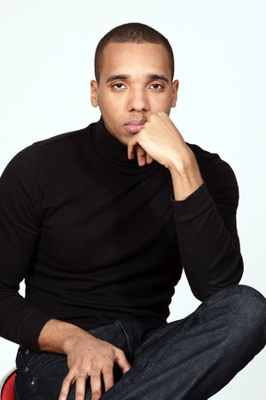 Portrait of a young african-american pensive man sitting on the chairの写真素材