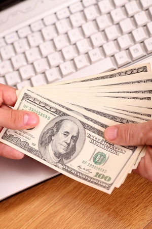 two businessmen passing each other money. keyboard in the background.の写真素材